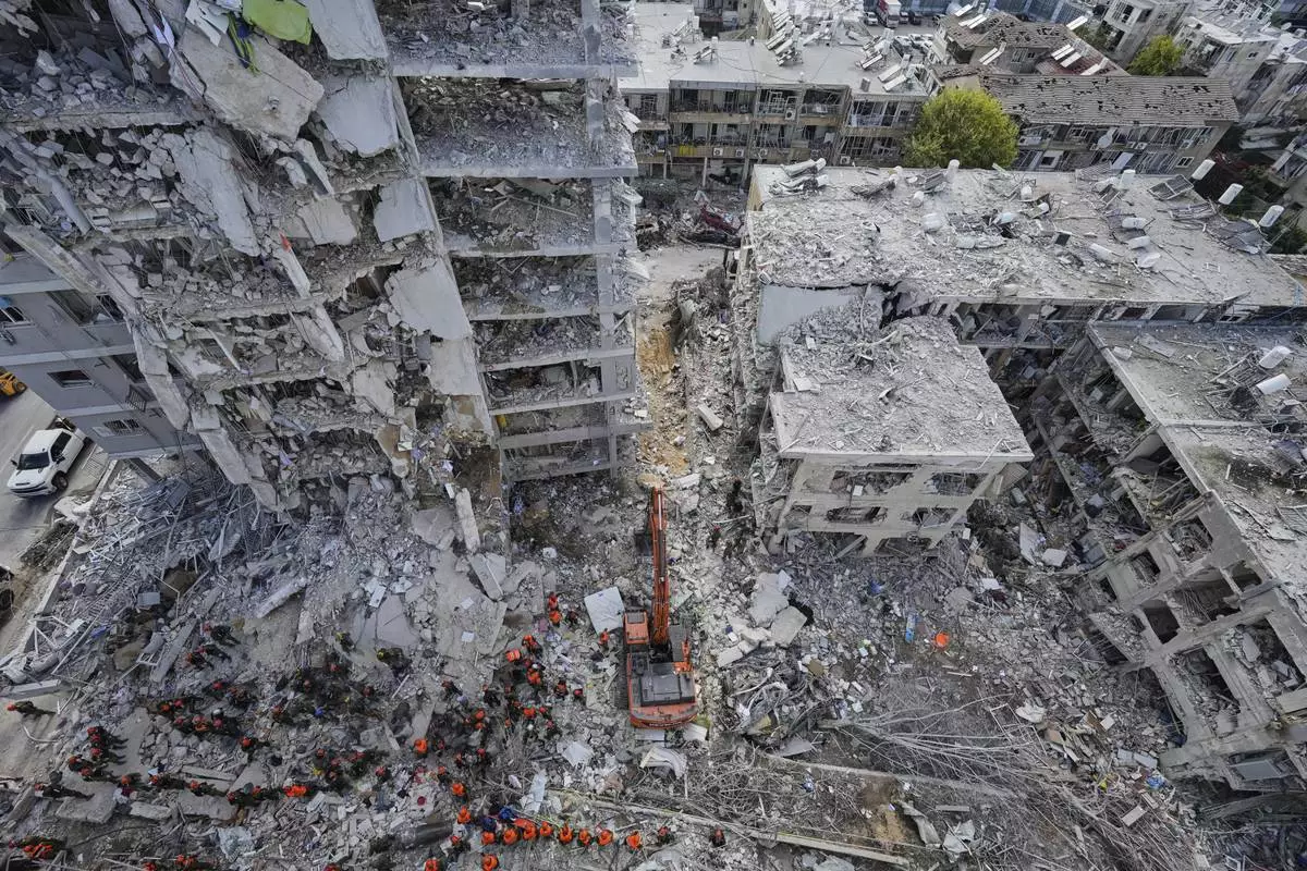 Israeli soldiers search through the rubble of residential buildings destroyed by an Iranian missile strike in Bat Yam, central Israel, Sunday, June 15, 2025. (AP Photo/Baz Ratner)