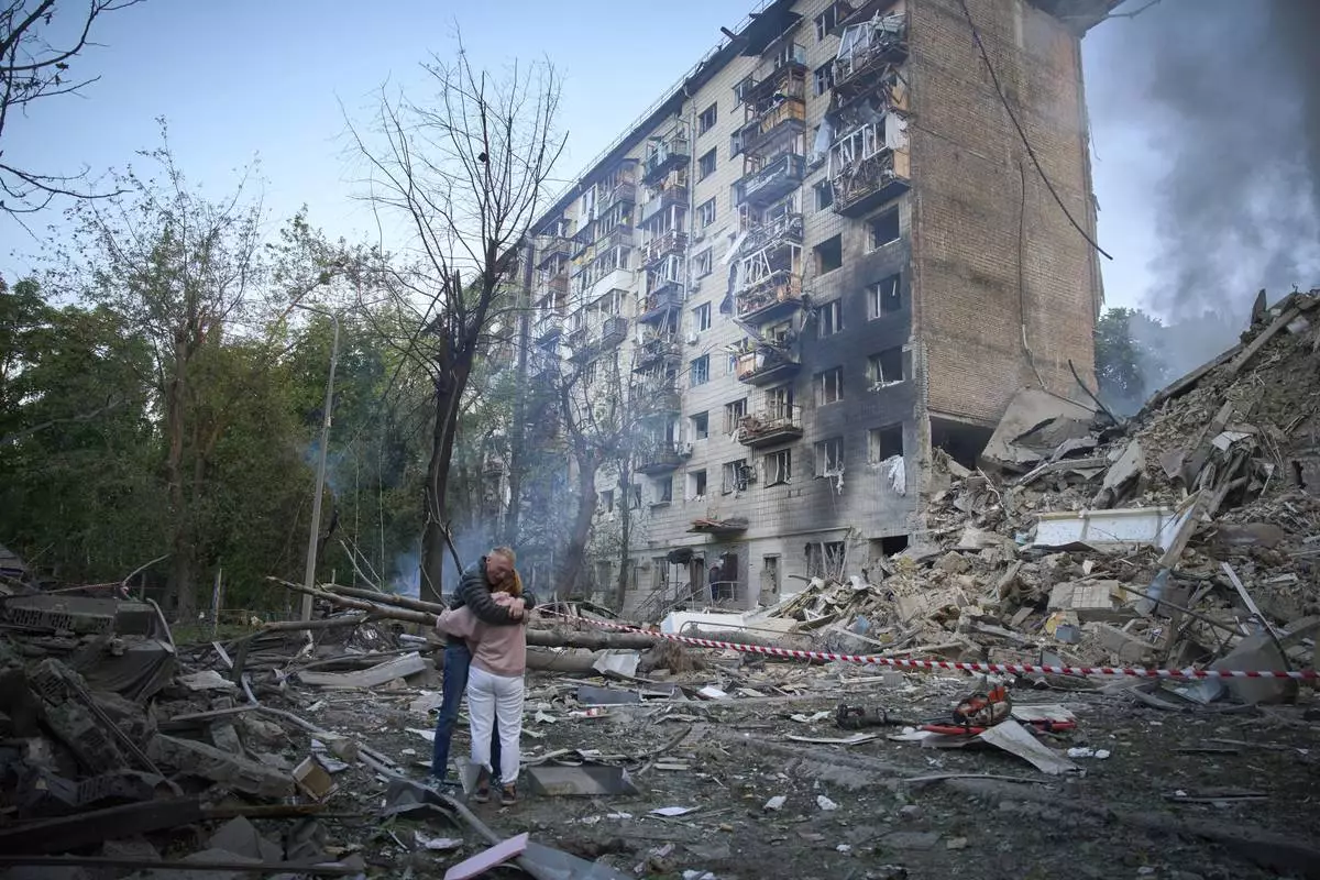 Residents embrace after a Russian missile hit a multi-storey apartment during Russia's combined missile and drone air attack in Kyiv, Ukraine, Tuesday, June 17, 2025. (AP Photo/Efrem Lukatsky)