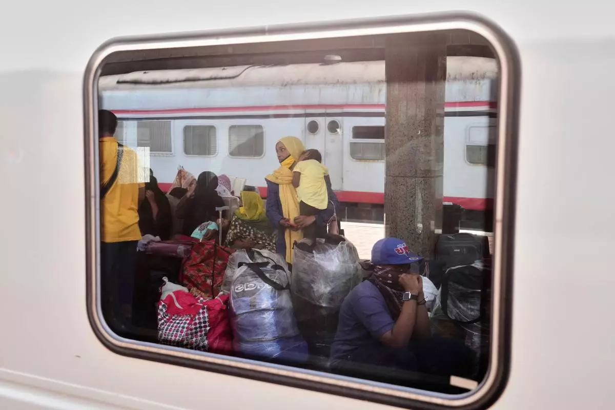 A Sudanese woman and children, who were driven from their homes and are now returning, wait for their train to Aswan at Cairo's Ramses railway station, Egypt, Monday, July 21, 2025. (AP Photo/Amr Nabil)