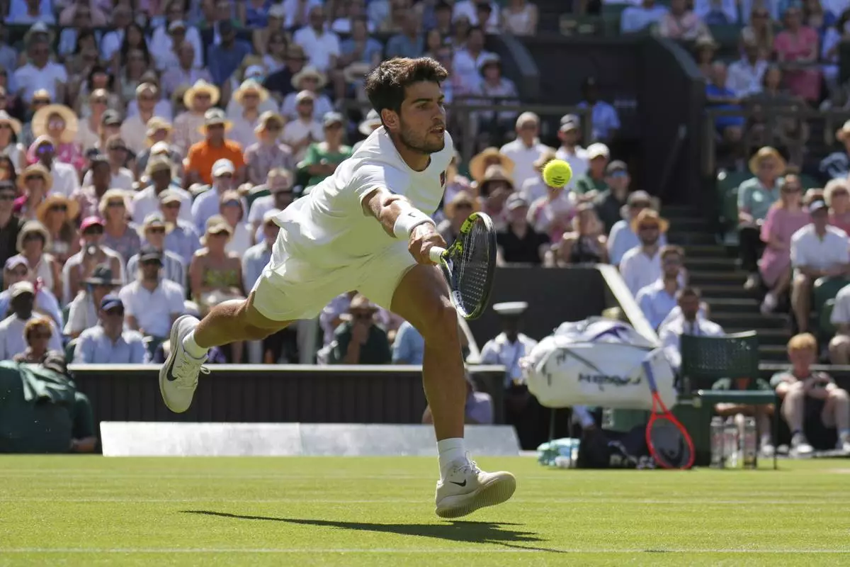 Spain's Carlos Alcaraz returns to Taylor Fritz of the U.S. in a men's singles semifinal at the Wimbledon Tennis Championships in London, Friday, July 11, 2025. (AP Photo/Kin Cheung)
