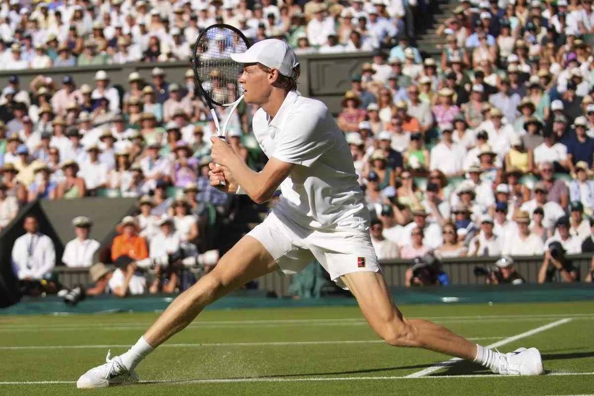 Jannik Sinner of Italy slides as he plays a return to Novak Djorkovic of Serbia during the men's semifinal singles match at the Wimbledon Tennis Championships in London, Friday, July 11, 2025.(AP Photo/Joanna Chan)