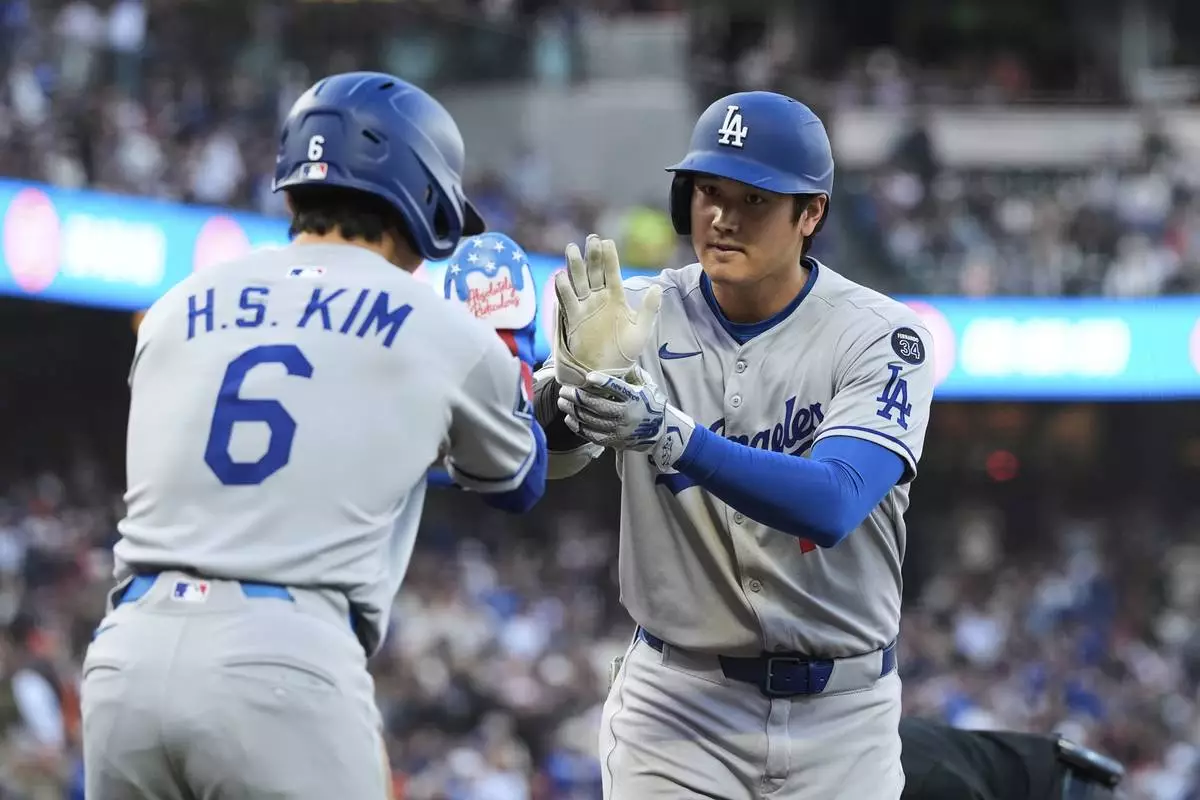 Los Angeles Dodgers' Shohei Ohtani, right, celebrates with Hyeseong Kim after hitting a two-run home run during the third inning of a baseball game against the San Francisco Giants, Friday, July 11, 2025, in San Francisco. (AP Photo/Godofredo A. Vásquez)