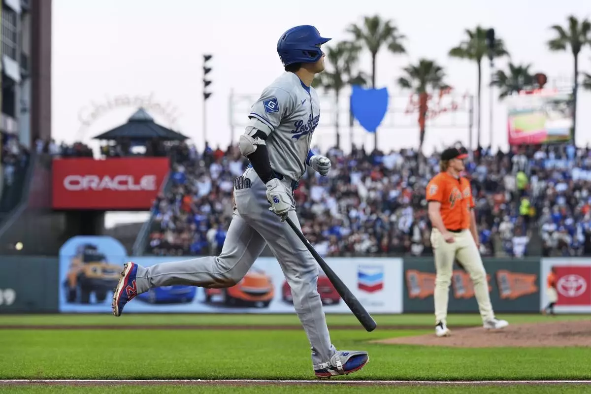 Los Angeles Dodgers' Shohei Ohtani, left, watches his two-run home run during the third inning of a baseball game against the San Francisco Giants, Friday, July 11, 2025, in San Francisco. (AP Photo/Godofredo A. Vásquez)
