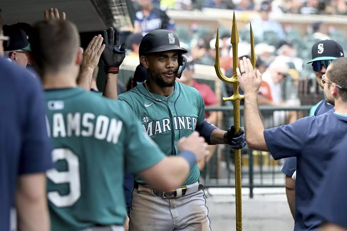 Seattle Mariners Julio Rodríguez (44) celebrates in the dugout after hitting a solo home run against the Detroit Tigers in the sixth inning of a baseball game, Saturday, July 12, 2025, in Detroit. (AP Photo/Lon Horwedel)