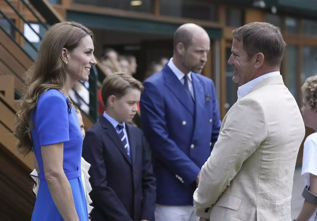 Britain's Prince William, second right, Kate, Princess of Wales, and Prince George meet Steve Backshall as they arrive to attend the men's singles final match between Italy's Jannik Sinner and Spain's Carlos Alcaraz at the Wimbledon Tennis Championships in London Sunday July 13, 2025. (Andrew Matthews/Pool via AP)