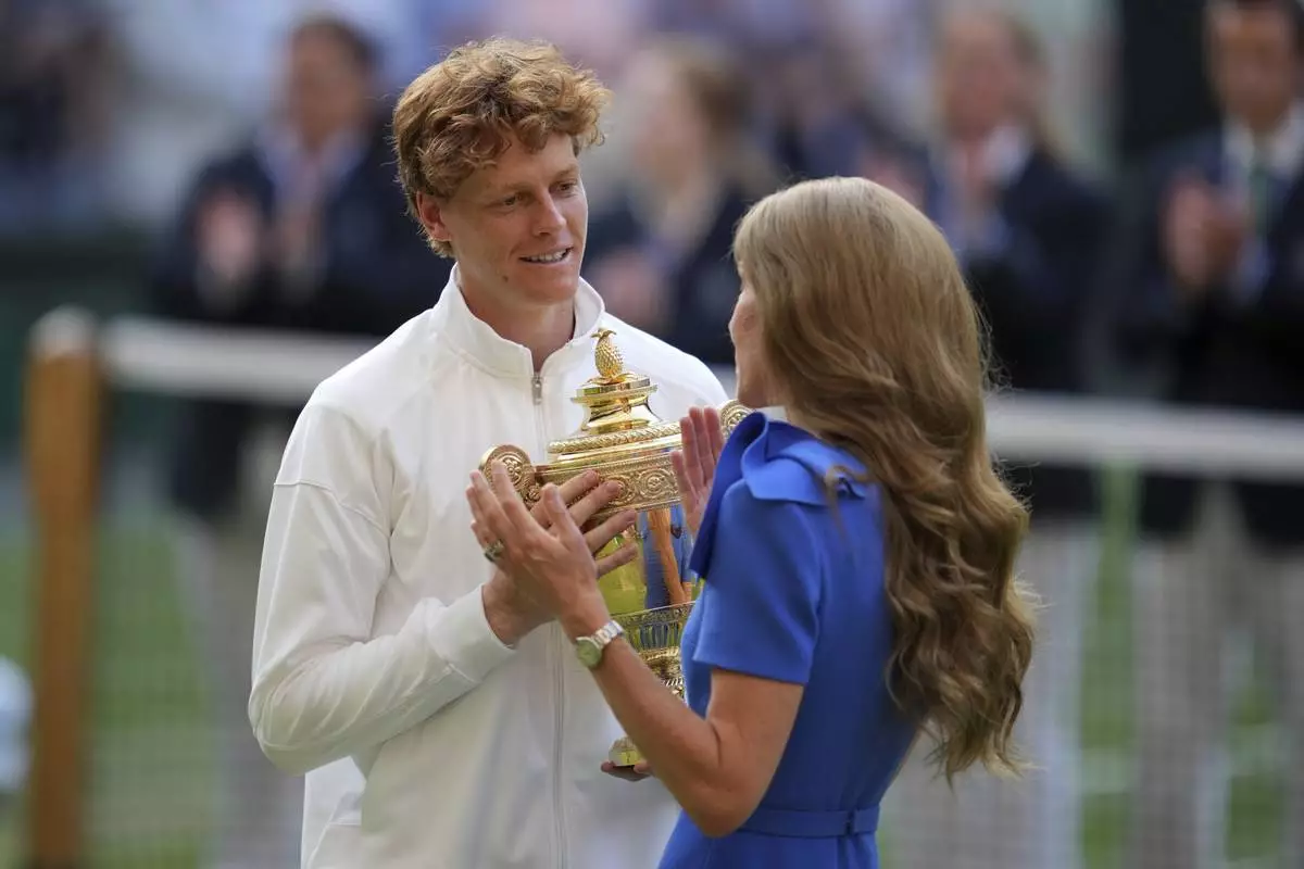 Italy's Jannik Sinner receives the trophy from Kate, Princess of Wales, after beating Carlos Alcaraz of Spain to win the men's singles final at the Wimbledon Tennis Championships in London, Sunday, July 13, 2025. (AP Photo/Kin Cheung)