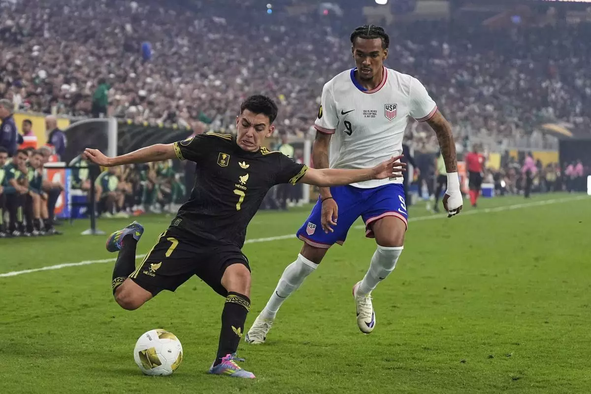 Mexico midfielder Gilberto Mora (7) makes a pass to the front of the net as United States forward Damion Downs (9) defends in the second half of the CONCACAF Gold Cup final soccer match in Houston, Sunday, July 6, 2025. (AP Photo/Ashley Landis)