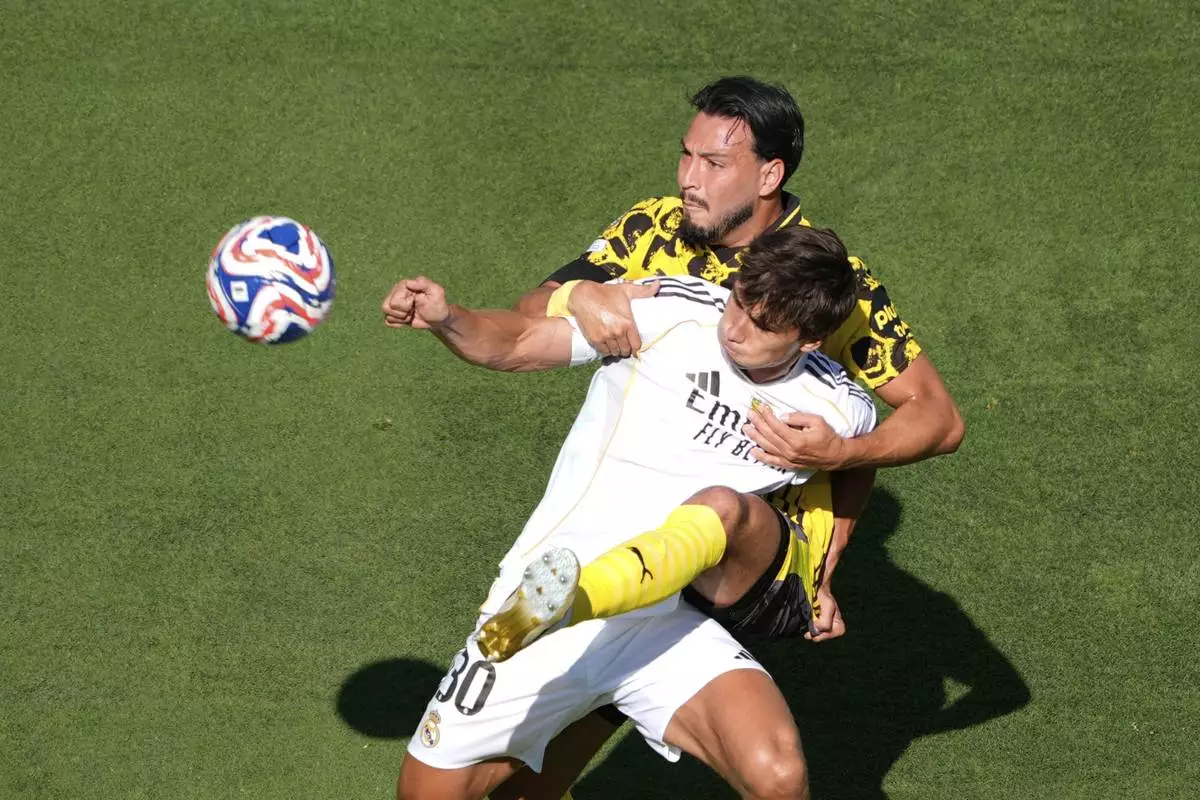 Real Madrid's Gonzalo Garcia, front, and Borussia Dortmund's Ramy Bensebaini compete for the ball during the Club World Cup quarterfinal soccer match between Real Madrid and Borussia Dortmund in East Rutherford, N.J., Saturday, July 5, 2025. (AP Photo/Pamela Smith)
