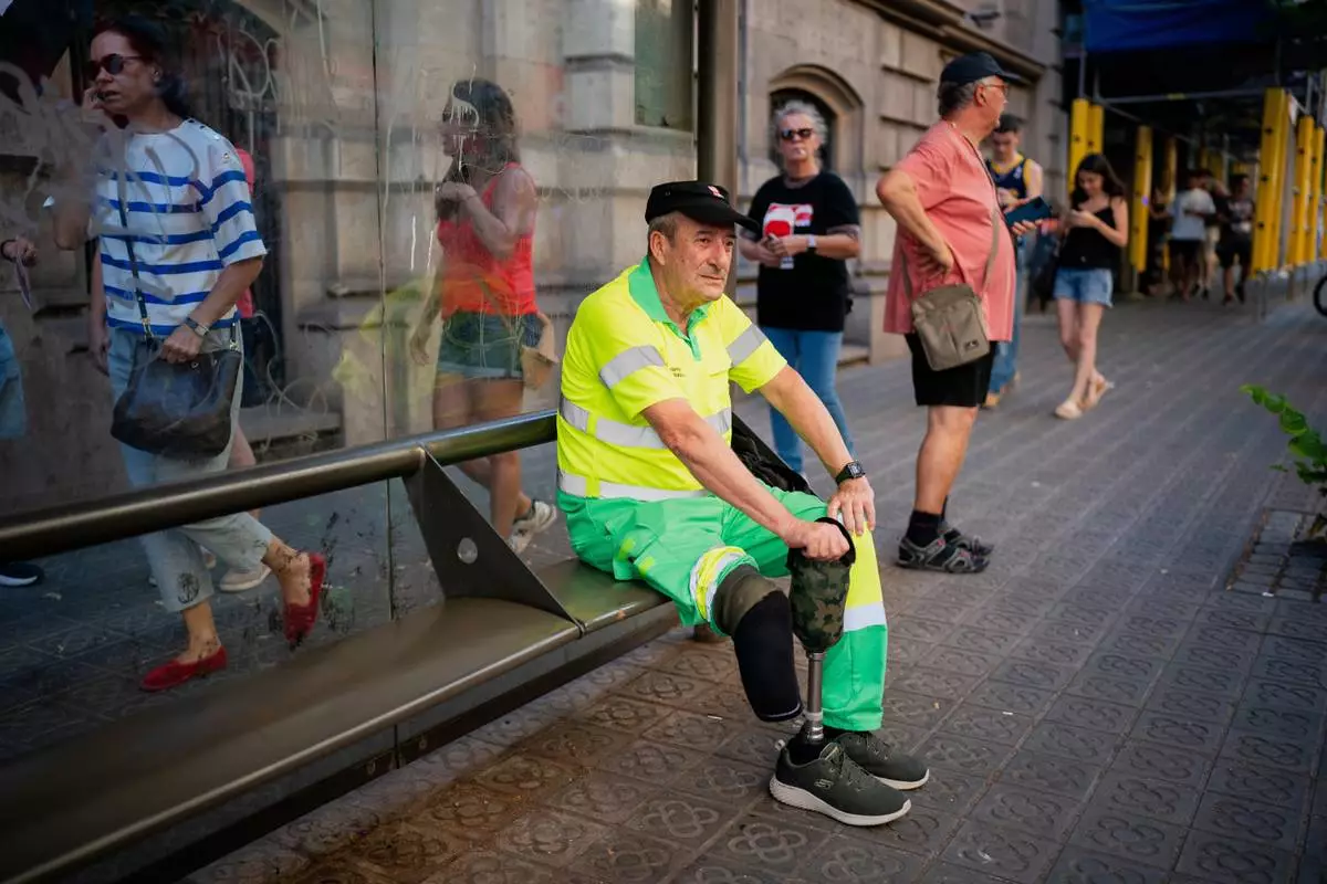 FILE - Street cleaner Raúl Rodriguez rests during a protest over the death of fellow cleaner during a recent heat wave in Barcelona, Spain, Wednesday, July 16, 2025. (AP Photo/Joan Mateu Parra, File)
