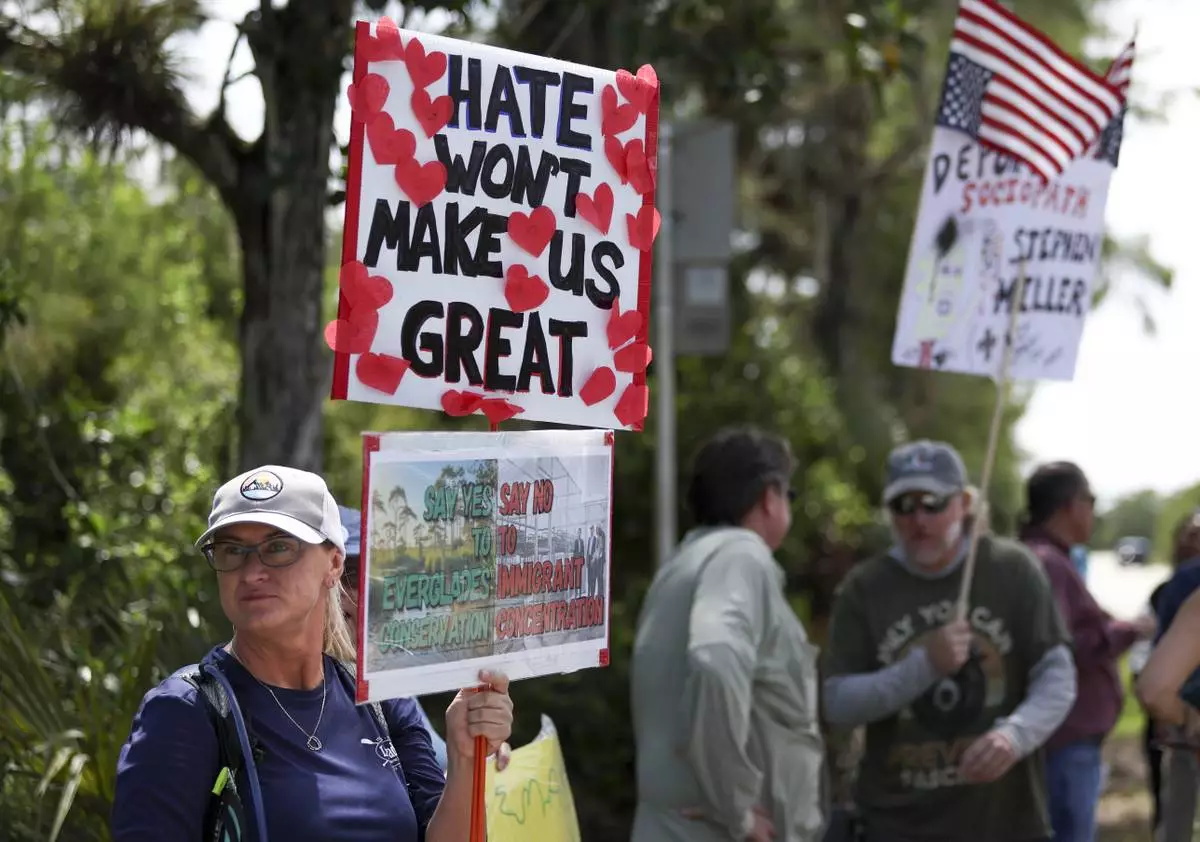 A protester stands outside the migrant detention facility dubbed "Alligator Alcatraz" at the Dade-Collier Training and Transition Facility, Saturday, July 12, 2025, in Ochopee, Fla. (AP Photo/Alexandra Rodriguez)