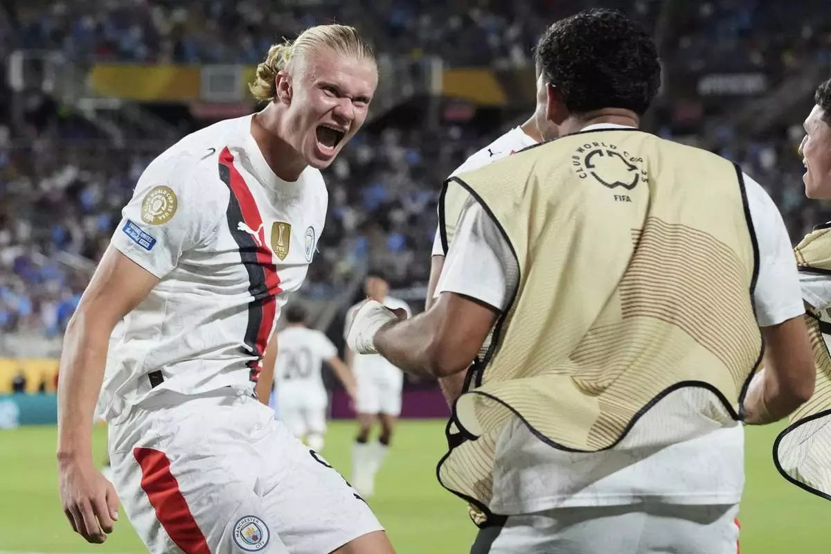 Manchester City's Erling Haaland, left, celebrates after scoring his team's second goal during the Club World Cup round of 16 soccer match between Manchester City and Al Hilal in Orlando, Fla., Monday, June 30, 2025. (AP Photo/John Raoux)