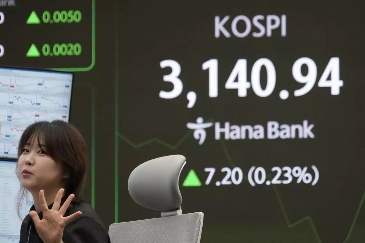 A currency trader works near a screen showing the Korea Composite Stock Price Index (KOSPI) at the foreign exchange dealing room of the KEB Hana Bank headquarters in Seoul, South Korea, Thursday, July 10, 2025. (AP Photo/Ahn Young-joon)