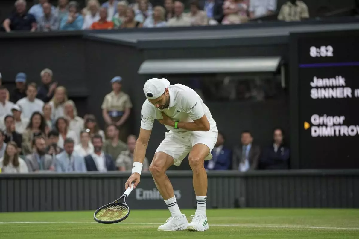 Bulgaria's Grigor Dimitrov clutches his chest with an injury which forced him to retire injured from a fourth round men's singles match against Italy's Jannik Sinner at the Wimbledon Tennis Championships in London, Monday, July 7, 2025. (AP Photo/Kin Cheung)