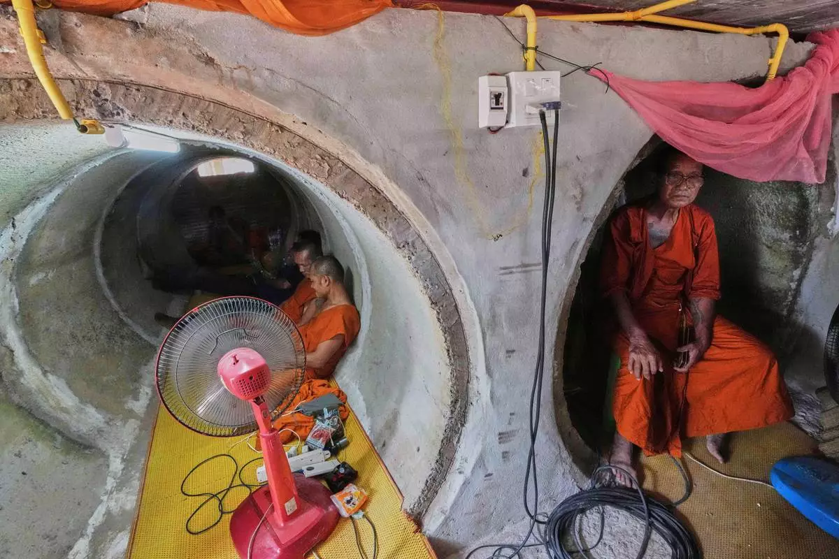 Abbot Phut Analayo, right, and other monks and residents who fled clashes between Thai and Cambodian soldiers take shelter in Surin province, Thailand, Saturday, July 26, 2025. (AP Photo/Sakchai Lalit)