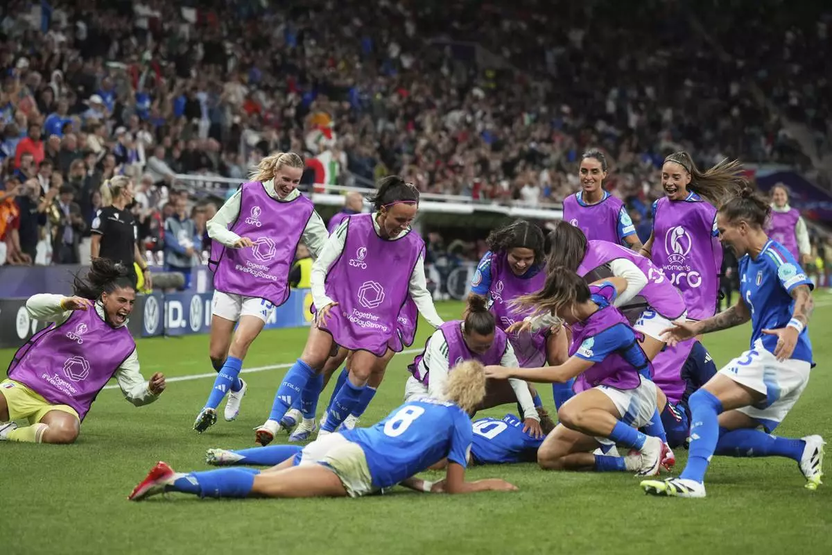 Italy players run celebrating to teammate Cristiana Girelli after she scored the opening goal during the Euro 2025, group B, soccer match between Portugal and Italy at Stade de Geneve in Geneva, Switzerland, Monday, July 7, 2025. (AP Photo/Alessandra Tarantino)