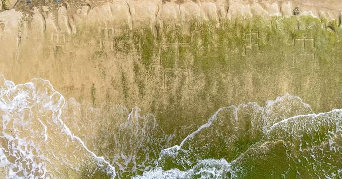 Early Hawaiian petroglyphs on a beach are visible again with changing tides and shifting sands