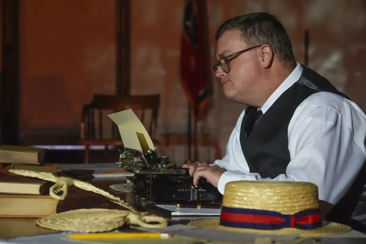 Anthony Smith who plays the roles of Walter White and Sue Hicks in the play "Destiny in Dayton" sits with a typewriter during a rehearsal, July 8, 2025, in Dayton, Tenn. (AP Photo/Mike Stewart)