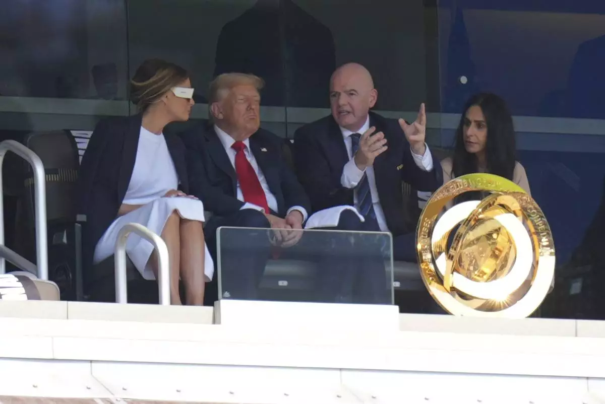 FIFA President Gianni Infantino, right, speaks with President Donald Trump and first lady Melania Trump during the Club World Cup final soccer match between Chelsea and PSG in East Rutherford, N.J., Sunday, July 13, 2025. (AP Photo/Seth Wenig)