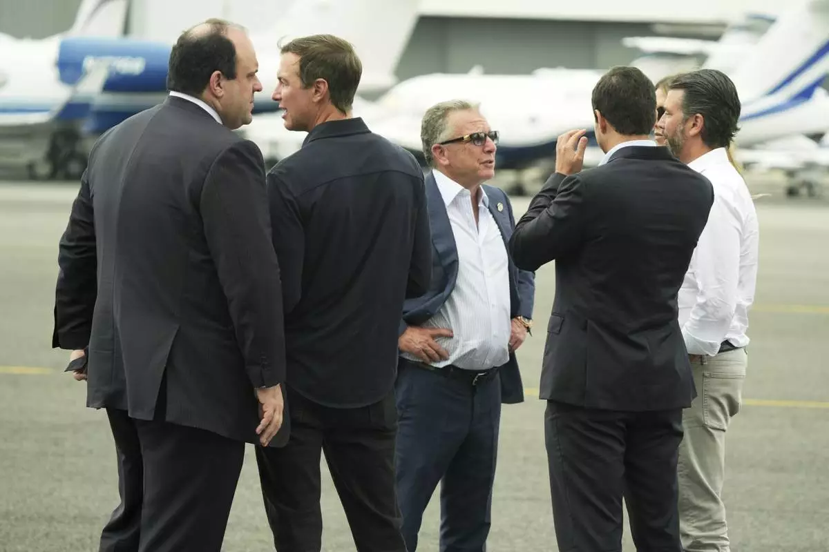 Boris Epshteyn, from left, Jared Kushner, White House special envoy Steve Witkoff, Michael Boulos, Bettina Anderson, partially obstructed and Donald Trump Jr. speak before the arrival of President Donald Trump at Teterboro Airport in Teterboro, N.J., en route to attend the Club World Cup final soccer match, Sunday, July 13, 2025. (AP Photo/Jacquelyn Martin)