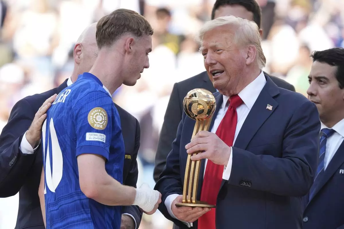 President Donald Trump, right, presents the Golden Ball award to Chelsea's Cole Palmer at the Club World Cup final soccer match between Chelsea and PSG at MetLife Stadium in East Rutherford, N.J., Sunday, July 13, 2025. (AP Photo/Jacquelyn Martin)