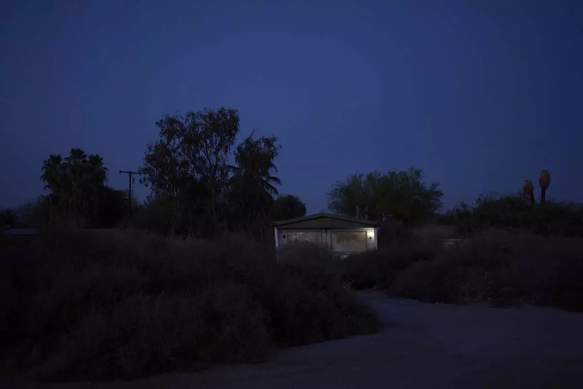 A light shines from a mobile home at dusk in Thermal, Calif., Tuesday, April 15, 2025. (AP Photo/Jae C. Hong)