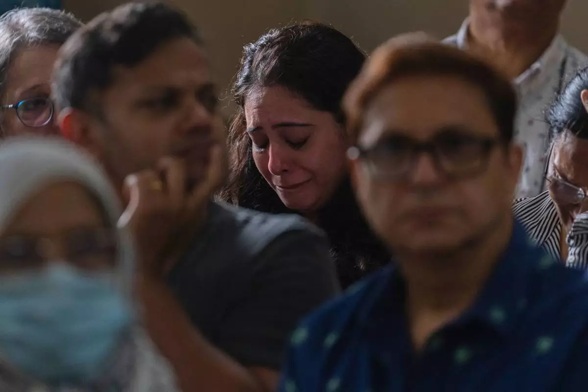 A relative of the crew of the Air India flight that crashed in Ahmedabad last month, mourns during a prayer meeting at a church in Mumbai, India, Saturday, July 12, 2025. (AP Photo/ Rafiq Maqbool)