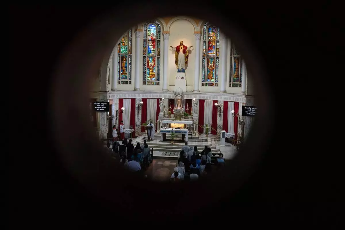 People offer prayers for crew members of the Air India flight that crashed in Ahmedabad last month during a prayer meeting at a church in Mumbai, India, Saturday, July 12, 2025. (AP Photo/ Rafiq Maqbool)