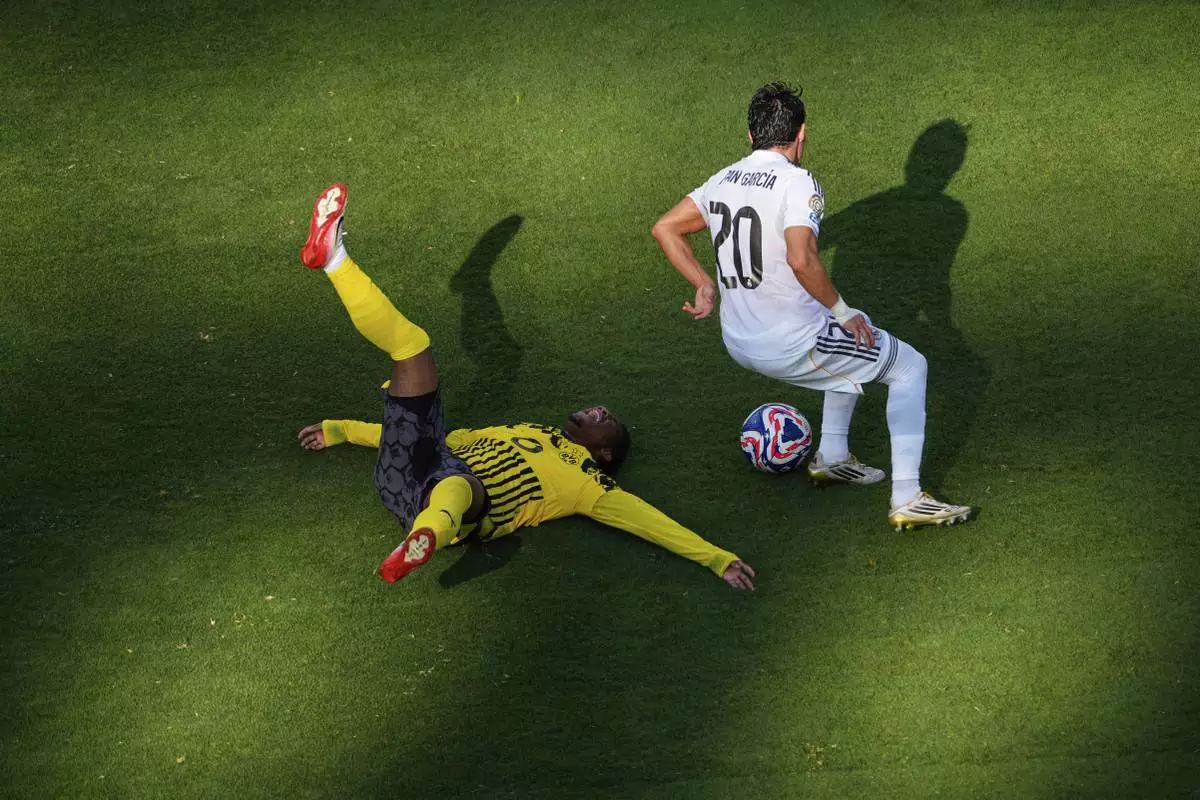 Borussia Dortmund's Julien Duranville, left, grimaces in pain past Real Madrid's Fran Garcia during the Club World Cup quarterfinal soccer match between Real Madrid and Borussia Dortmund in East Rutherford, N.J., Saturday, July 5, 2025. (AP Photo/Pamela Smith)