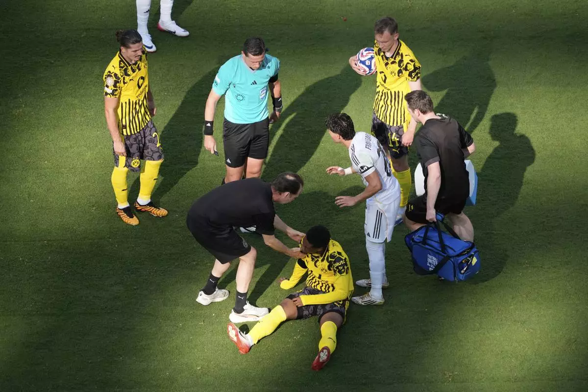 Borussia Dortmund's Julien Duranville, bottom, receives medical treatment during the Club World Cup quarterfinal soccer match between Real Madrid and Borussia Dortmund in East Rutherford, N.J., Saturday, July 5, 2025. (AP Photo/Pamela Smith)