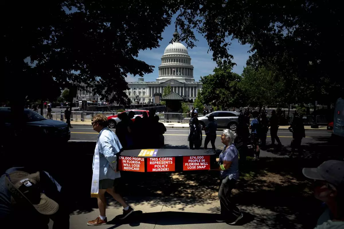 Demonstrators carry cardboard caskets in front of the U.S. Capitol in protest of President Donald Trump's tax breaks and spending cuts package, Monday, June 30, 2025, in Washington. (AP Photo/Julia Demaree Nikhinson)