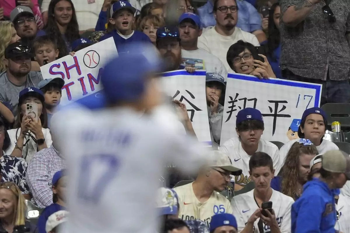 Fans cheer as Los Angeles Dodgers' Shohei Ohtani bats during the eighth inning of a baseball game against the Milwaukee Brewers, Monday, July 7, 2025, in Milwaukee. (AP Photo/Aaron Gash)