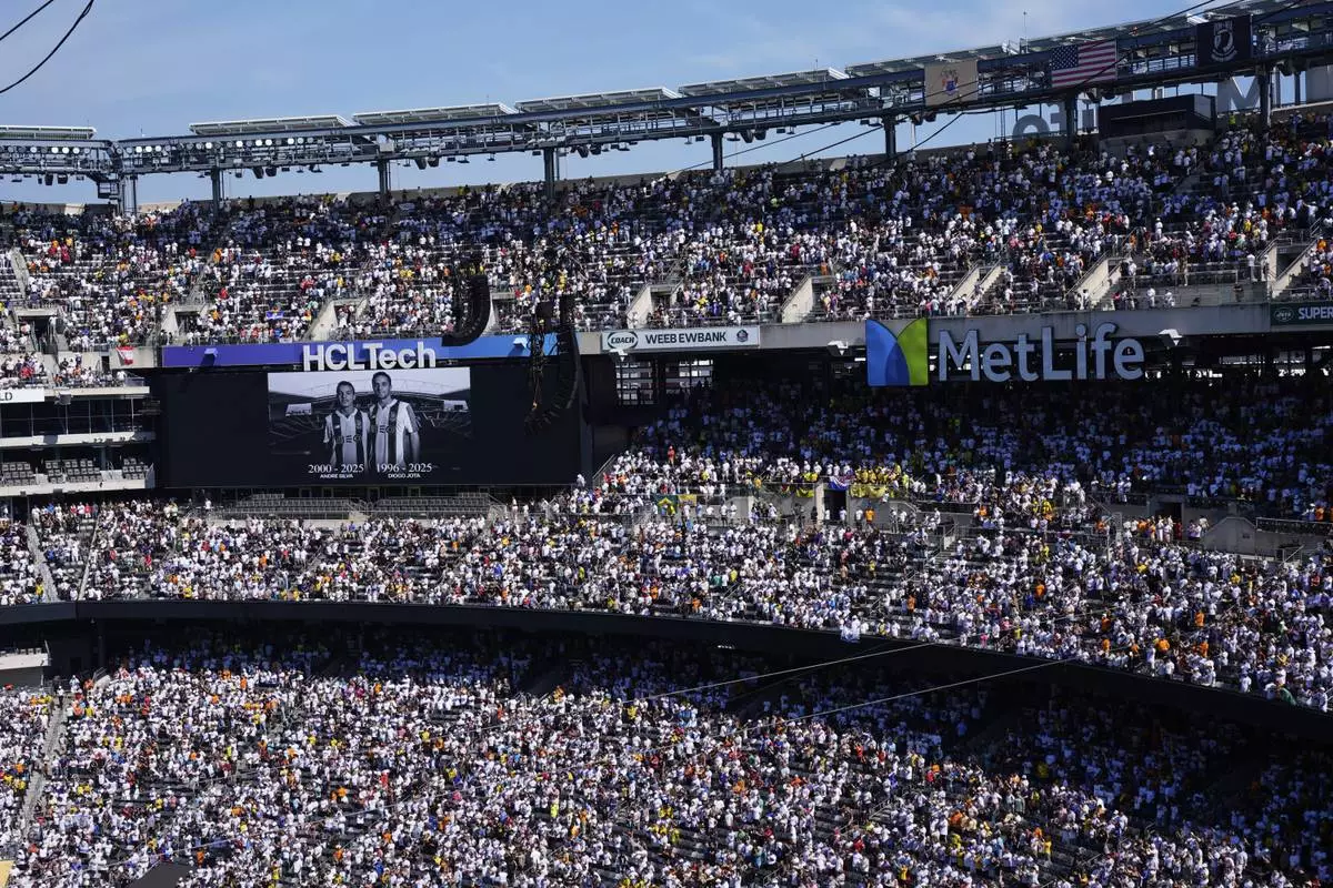 Fans observe a minute of silent in memory of Portugal international and Liverpool player Diogo Jota and his brother Andre Silva, prior the Club World Cup quarterfinal soccer match between Real Madrid and Borussia Dortmund in East Rutherford, N.J., Saturday, July 5, 2025. (AP Photo/Pamela Smith)