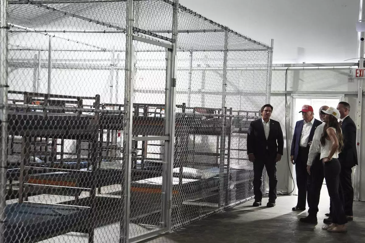 President Donald Trump, Gov. Ron DeSantis, R-Fla., and Homeland Security Secretary Kristi Noem, and others, tour "Alligator Alcatraz," a new migrant detention facility at Dade-Collier Training and Transition facility, Tuesday, July 1, 2025, in Ochopee, Fla. (AP Photo/Evan Vucci)
