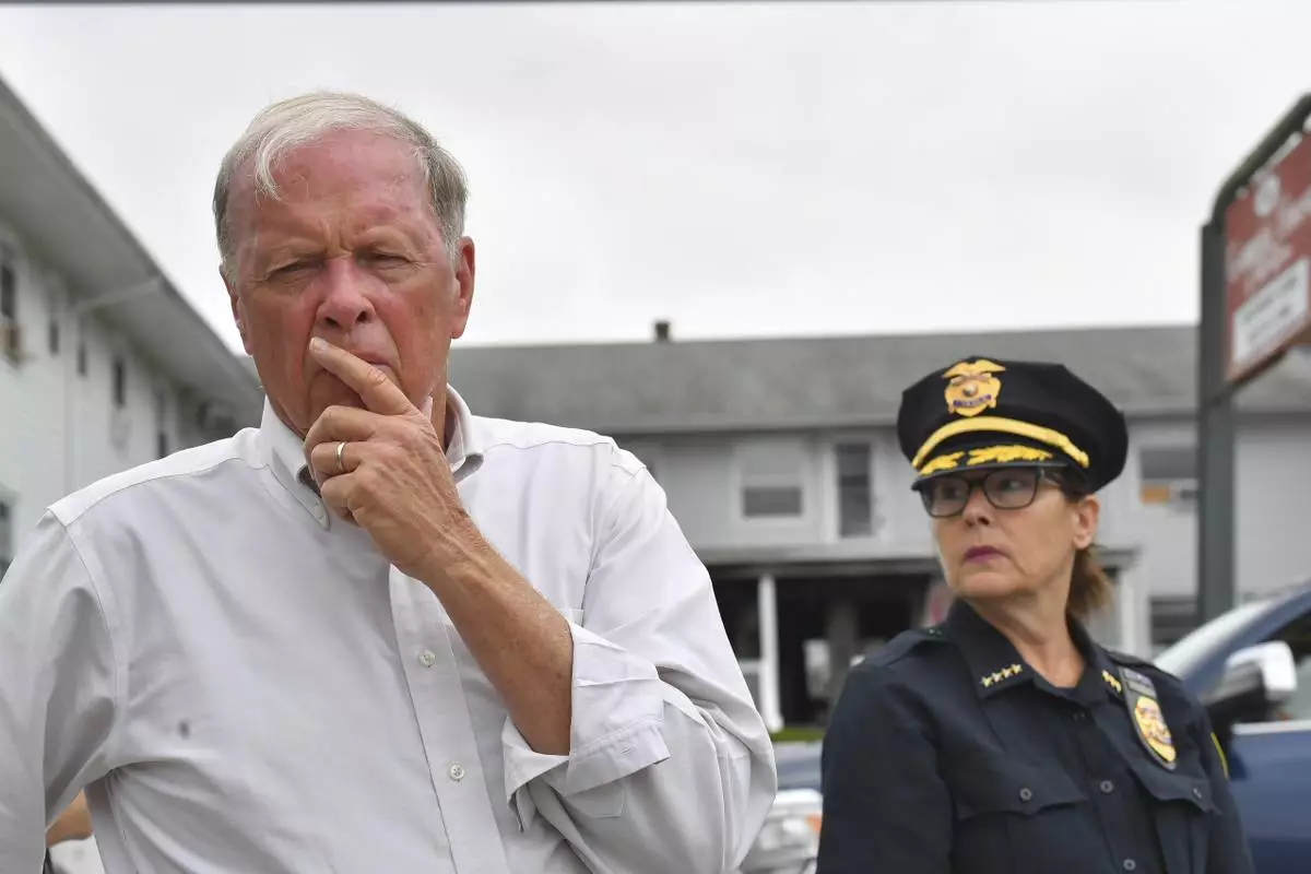 Fall River Mayor Paul Coogan, left, faces reporters near the Gabriel House assisted living facility, behind, Monday, July 14, 2025, following a fire at the facility that started late Sunday, in Fall River, Mass. (AP Photo/Steven Senne)