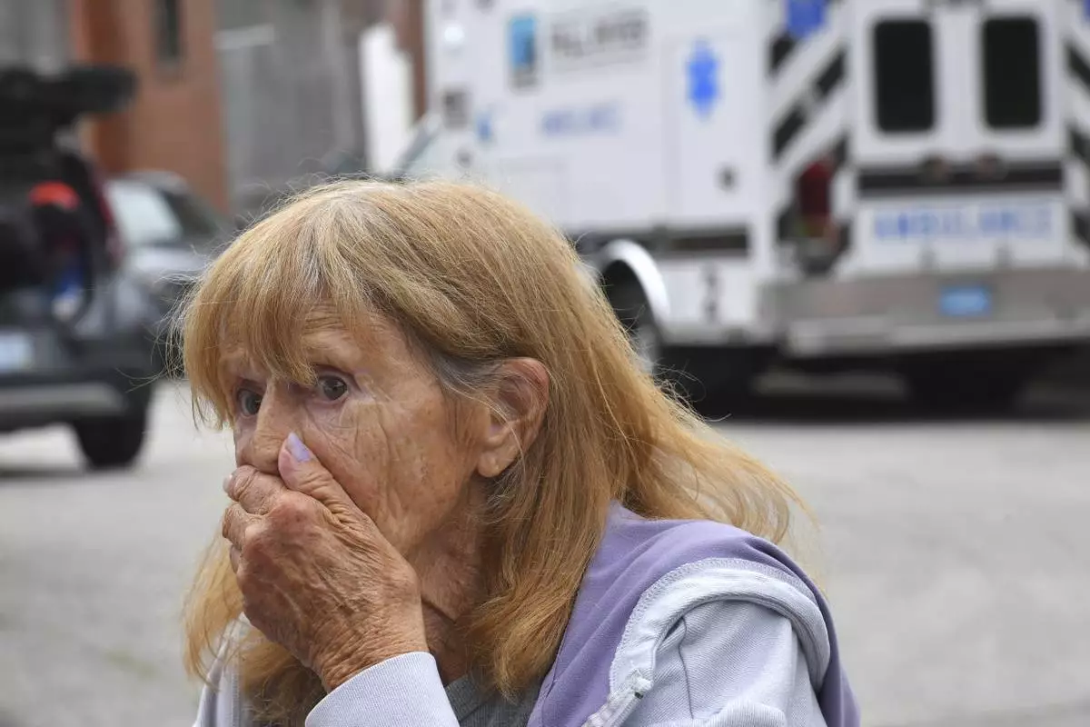 Donna Murphy, a resident at the Gabriel House assisted living facility, in Fall River, Mass., speaks with members of the media outside a temporary shelter, Monday, July 14, 2025, in Fall River, Mass., following a fire at the Gabriel House that started late Sunday and resulted in multiple fatalities. (AP Photo/Steven Senne)