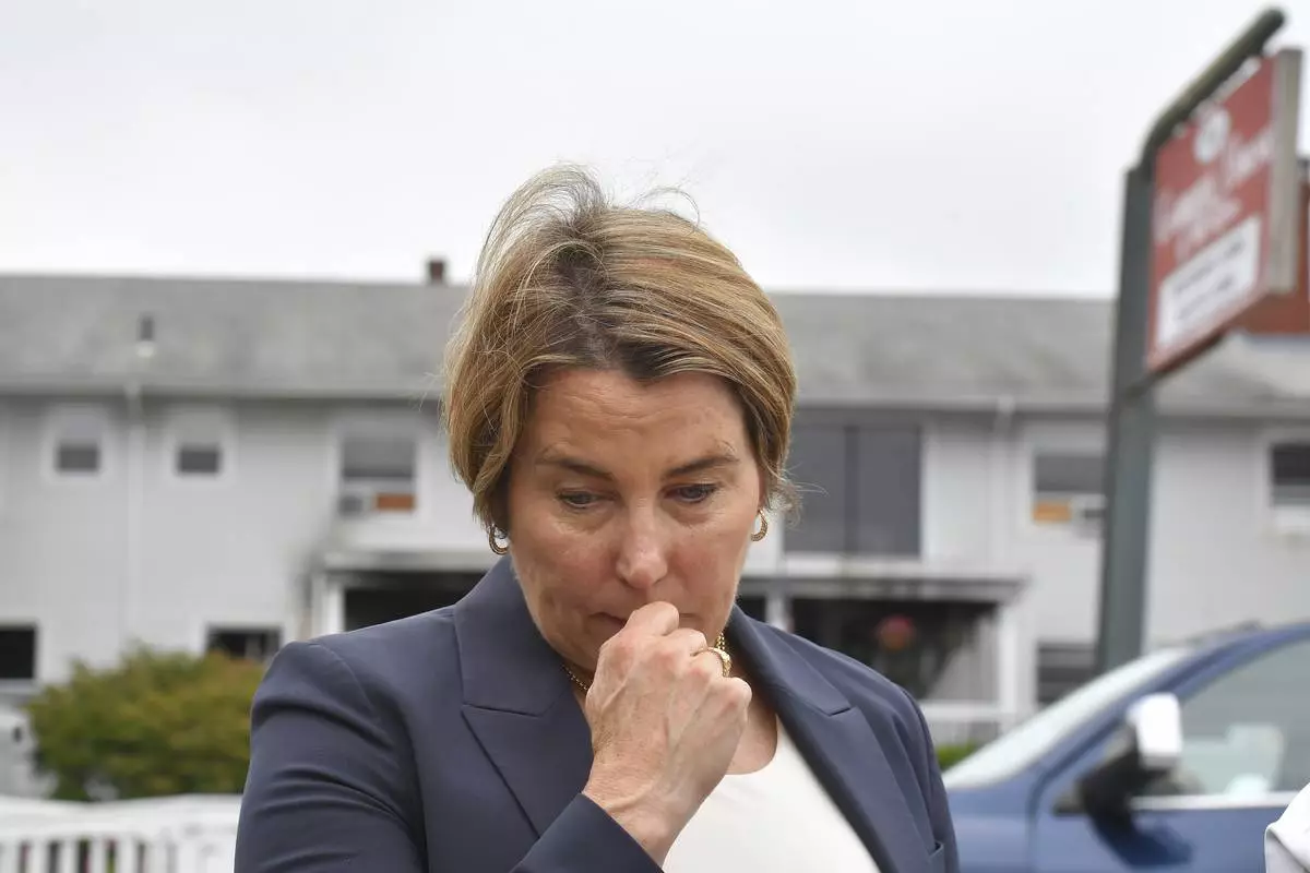 Massachusetts Gov. Maura Healey approaches a news conference to face reporters Monday, July 14, 2025, near the Gabriel House assisted living facility, behind, following a fire that started late Sunday in Fall River, Mass. (AP Photo/Steven Senne)