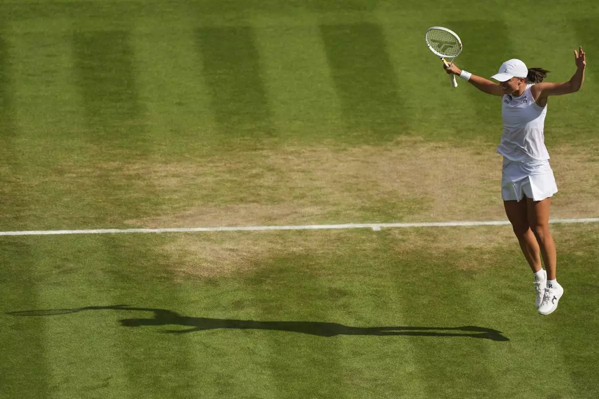 Iga Swiatek of Poland celebrates winning the women's singles final match against Amanda Anisimova of the U.S. at the Wimbledon Tennis Championships in London, Saturday, July 12, 2025.(AP Photo/Joanna Chan)