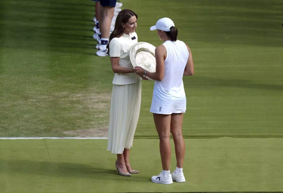 Britain's Kate, Princess of Wales presents the Venus Rosewater Dish to Iga Swiatek, following her victory over Amanda Anisimova in the Ladies' Singles Final at the Wimbledon Tennis Championships in London, Saturday, July 12, 2025. (Ben Whitley/PA via AP)