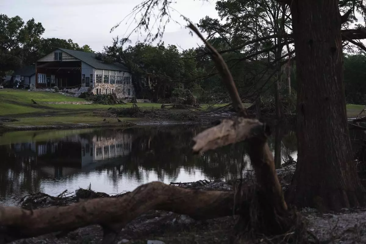 FILE - A building at Camp Mystic is reflected in water after a flash flood swept through the area July 7, 2025, in Hunt, Texas. (AP Photo/Eli Hartman, File)