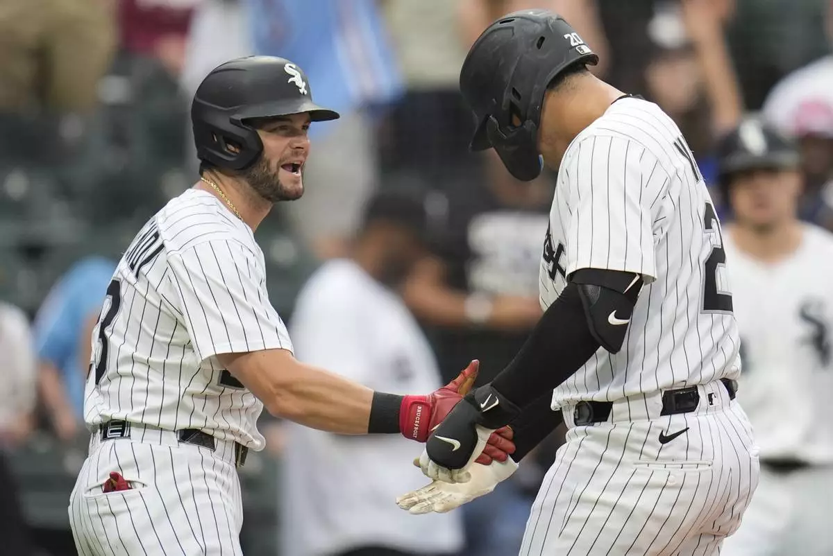 CORRECTS INNING - Chicago White Sox's Miguel Vargas (20), right, and fielder Andrew Benintendi (23) celebrate Vargas' three-run home run during the seventh inning of a baseball game against the Philadelphia Phillies, Wednesday, July 30, 2025, in Chicago. (AP Photo/Erin Hooley)