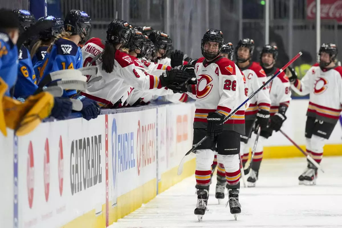 FILE - Ottawa Charge forward Emily Clark (26) is congratulated by her teammates after scoring a goal against the Toronto Sceptres during second period PWHL hockey action in Toronto, Feb. 1, 2025. (Arlyn McAdorey/The Canadian Press via AP, File)