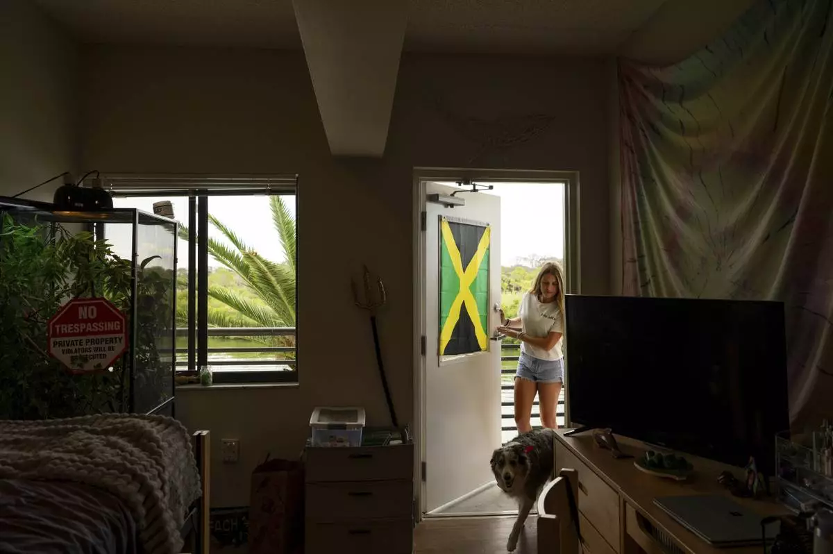 Sophie Nocera, 21, a senior at Eckerd College, walks into her dorm room with her dog Zuco on Wednesday, Aug. 20, 2025 in St. Petersburg, Fla. (AP Photo/Tina Russell)