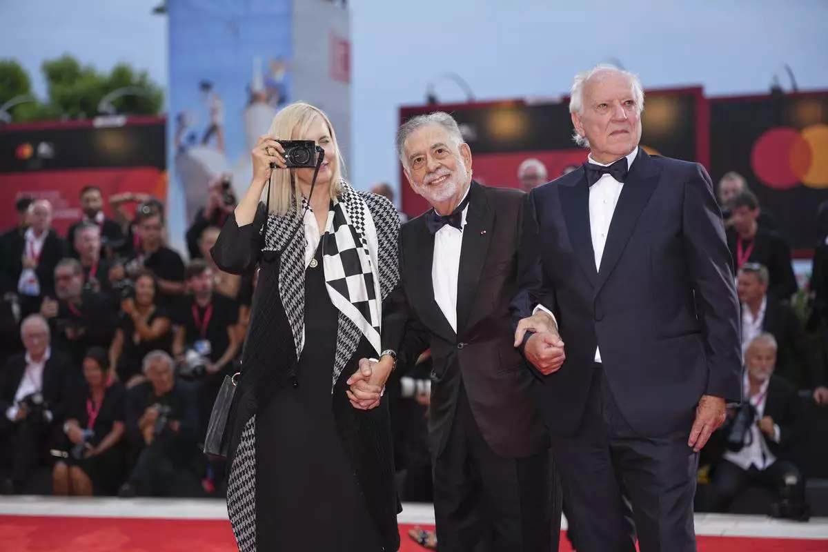 Lena Herzog, from left, Francis Ford Coppola, and Werner Herzog pose for photographers on the red carpet for the opening ceremony and the premiere of the film 'La Grazia' during the 82nd edition of the Venice Film Festival in Venice, Italy, on Wednesday, Aug. 27, 2025. (Photo by Scott A Garfitt/Invision/AP)