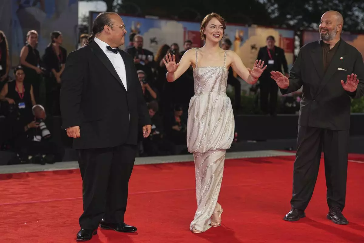Stavros Halkias, from left, Emma Stone, and director Yorgos Lanthimos pose for photographers on the red carpet for the film 'Bugonia' during the 82nd edition of the Venice Film Festival in Venice, Italy, on Thursday, Aug. 28, 2025. (Photo by Scott A Garfitt/Invision/AP)