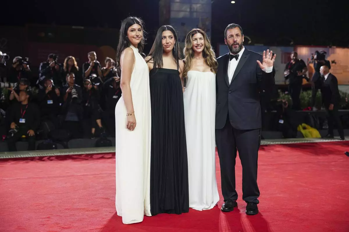Sunny Sandler, from left, Sadie Sandler, Jackie Sandler, and Adam Sandler pose for photographers at the red carpet for the film 'Jay Kelly' during the 82nd edition of the Venice Film Festival in Venice, Italy, on Thursday, Aug. 28, 2025. (Photo by Scott A Garfitt/Invision/AP)