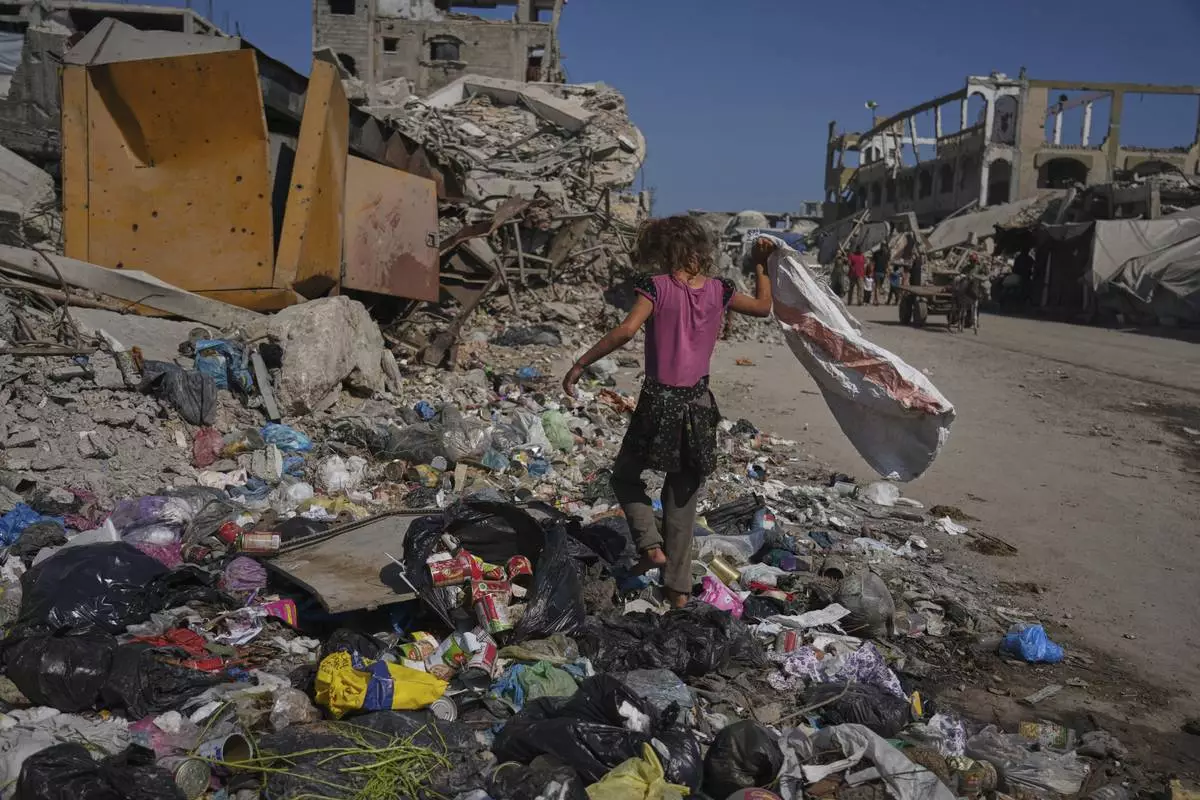 Malak Sobh, 7, searches through garbage for plastic to use as cooking fuel next to a makeshift tent camp for displaced Palestinians, where members of the Sobh family are taking shelter, in Gaza City on Thursday, July 24, 2025. (AP Photo/Jehad Alshrafi)