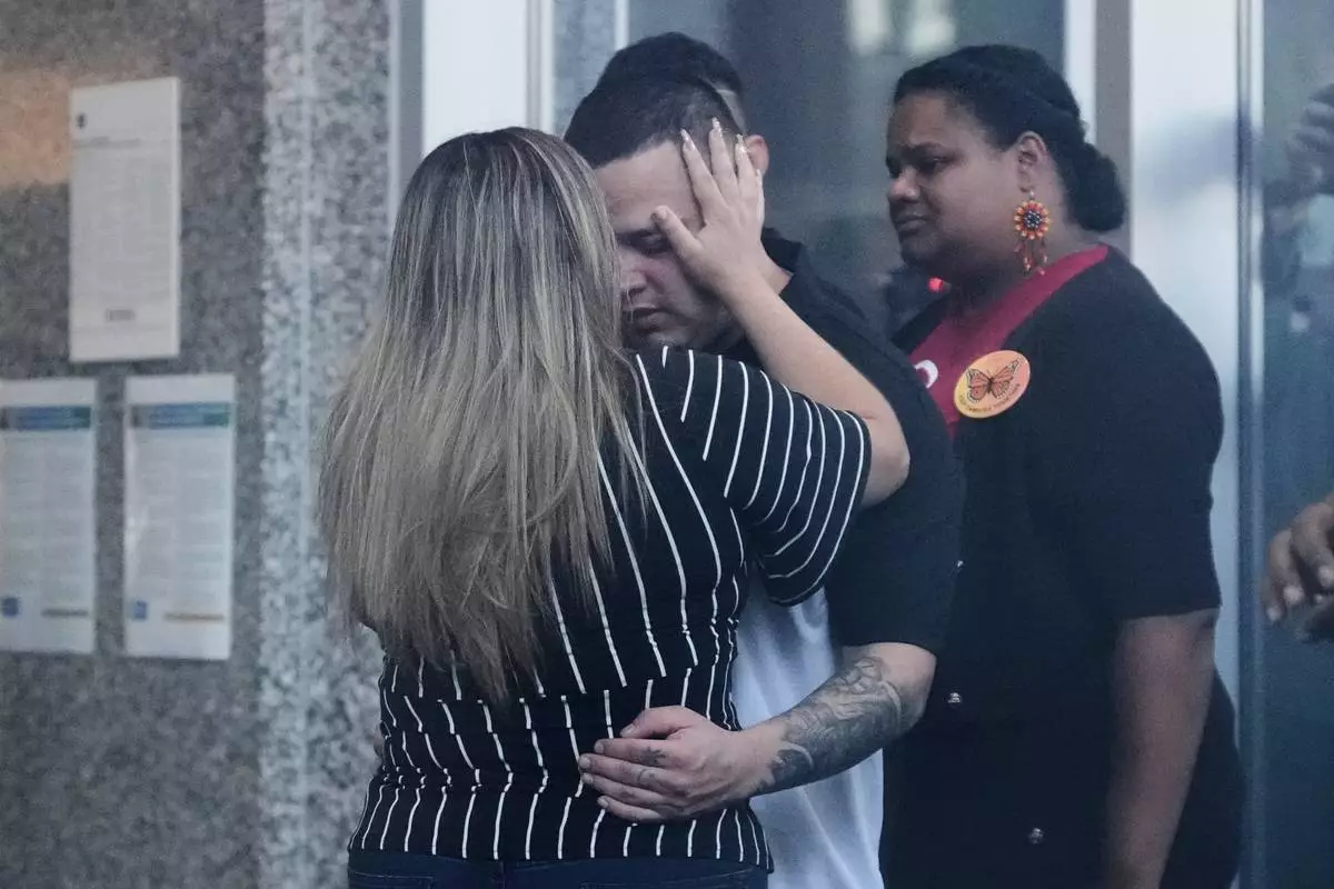 Jennifer Vasquez Sura, left, hugs her husband Kilmar Abrego Garcia at the Immigration and Customs Enforcement field office in Baltimore, Monday, Aug. 25, 2025. (AP Photo/Stephanie Scarbrough)