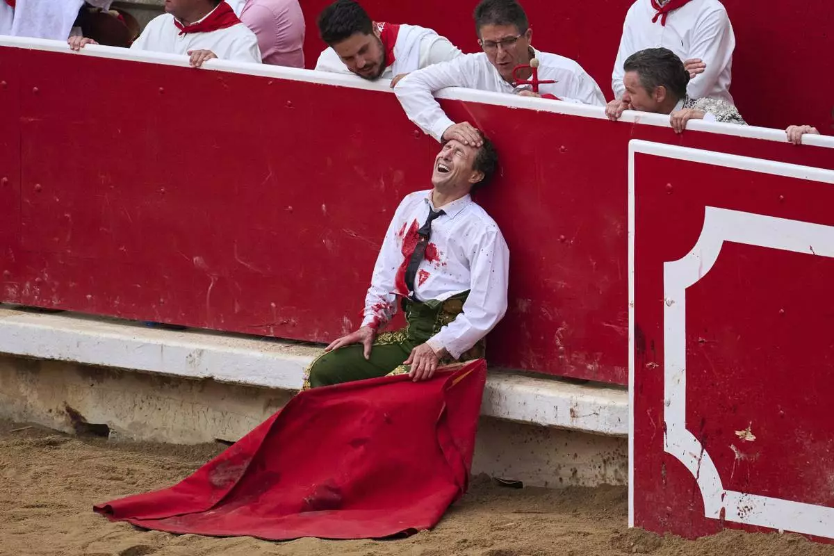 Spanish bullfighter Rafaelillo grimaces in pain after being gored by a bull during a bullfight at the San Fermín festival in Pamplona, Spain, July 12, 2025. (AP Photo/Miguel Oses)