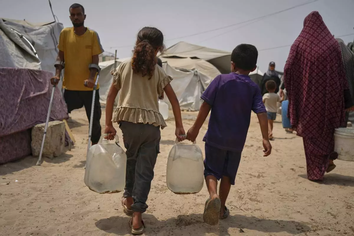 Palestinian children haul jerrycans of water collected from a distribution point in Gaza City, Aug. 12, 2025, amid scorching temperatures. (AP Photo/Jehad Alshrafi)
