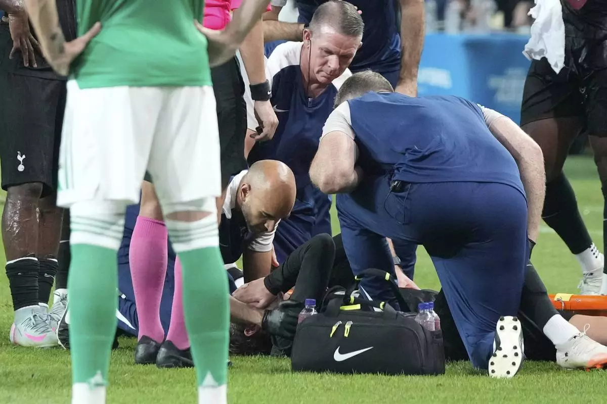 Tottenham Hotspur's James Maddison, bottom, gets medical assistance after being injured during a preseason friendly soccer match against Newcastle United at Seoul World Cup Stadium in Seoul, South Korea, Sunday, Aug. 3, 2025. (AP Photo/Ahn Young-joon)